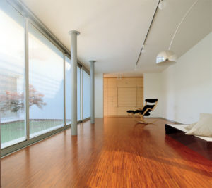 A room with wooden floors and large windows.