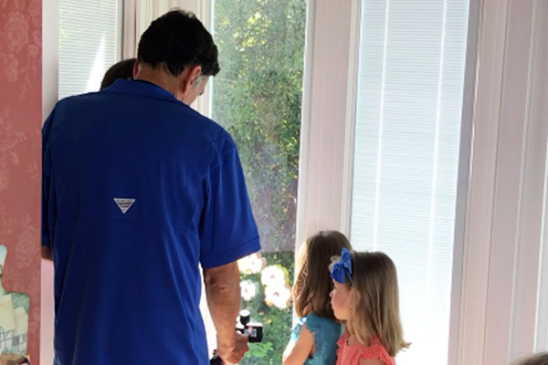 A man and two girls looking out the window.